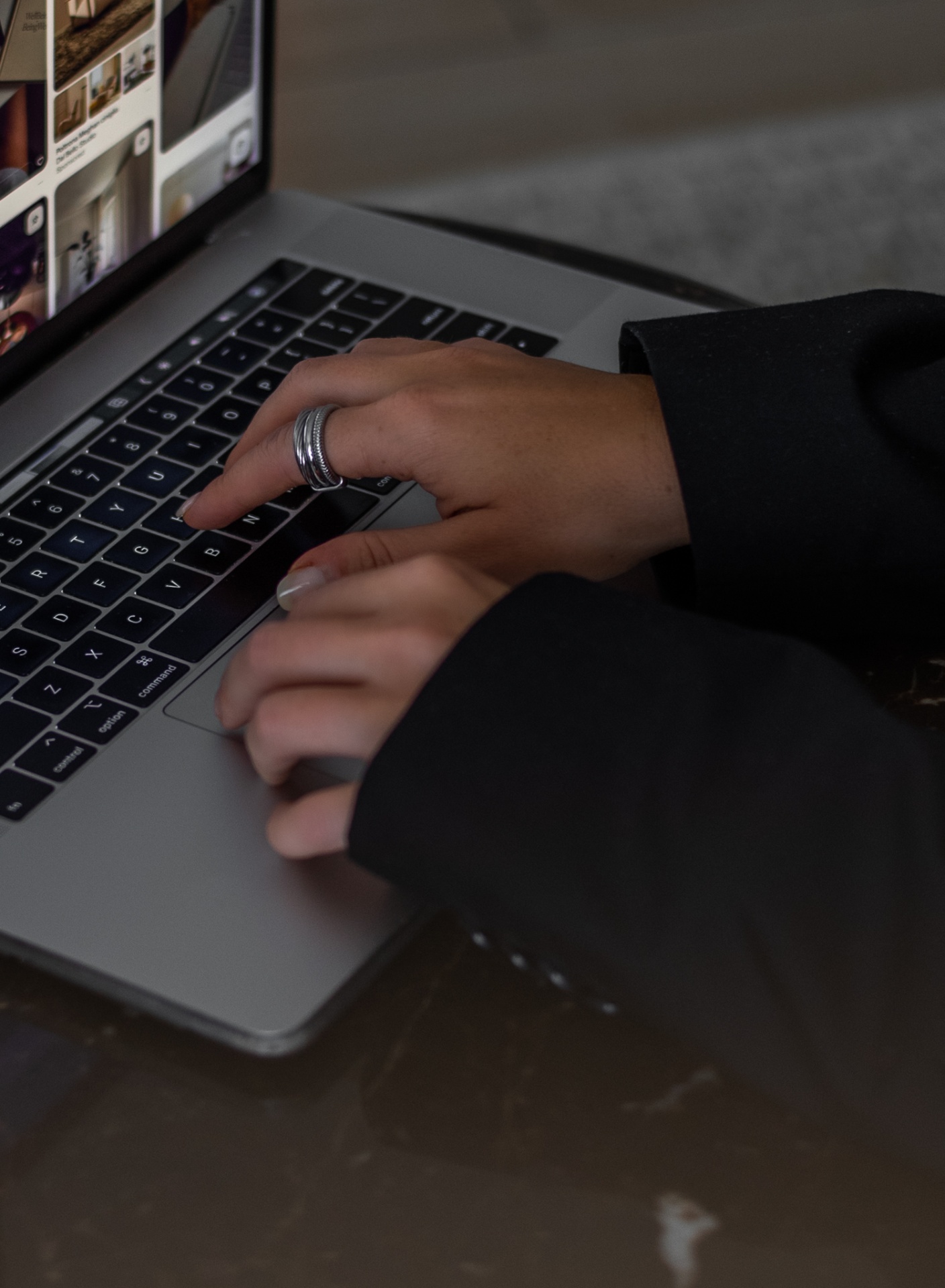 Close-up of hands typing on a laptop keyboard.